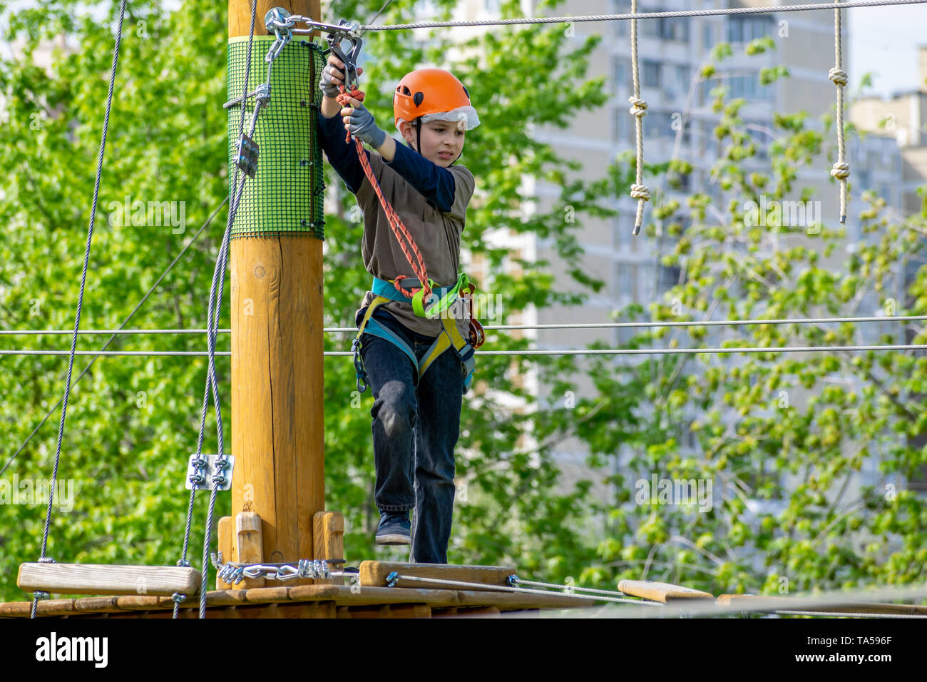 La pratique de son garçon compétences escalade dans un parc Banque D'Images