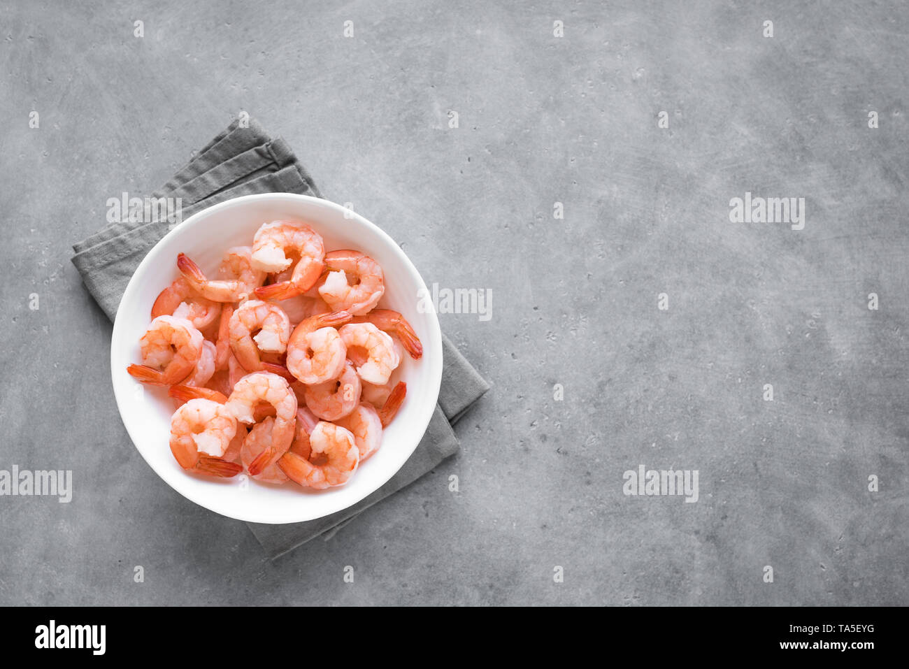 Les crevettes dans un bol, vue du dessus, copiez l'espace. Des fruits de mer - ingrédient queues prête pour la cuisson. Les crevettes bouillies. Banque D'Images