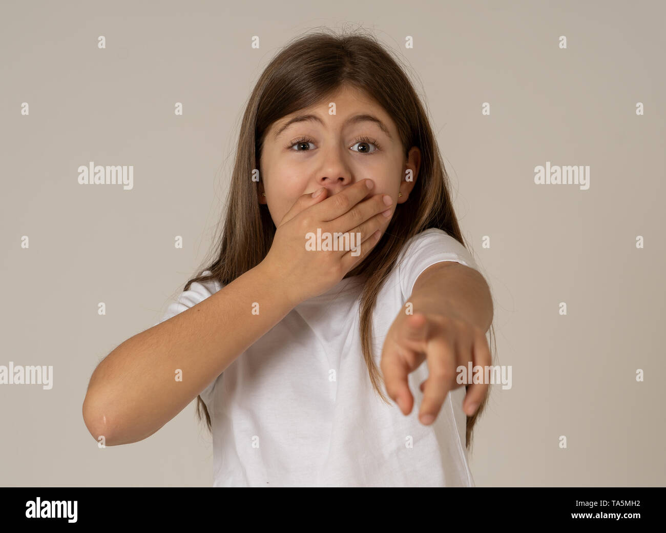 Portrait of Cute heureux, excité, drôle, souriant d'une jeune fille choquée surpris face à pointer du doigt quelque chose de bon et inattendu. Dans enfant Banque D'Images