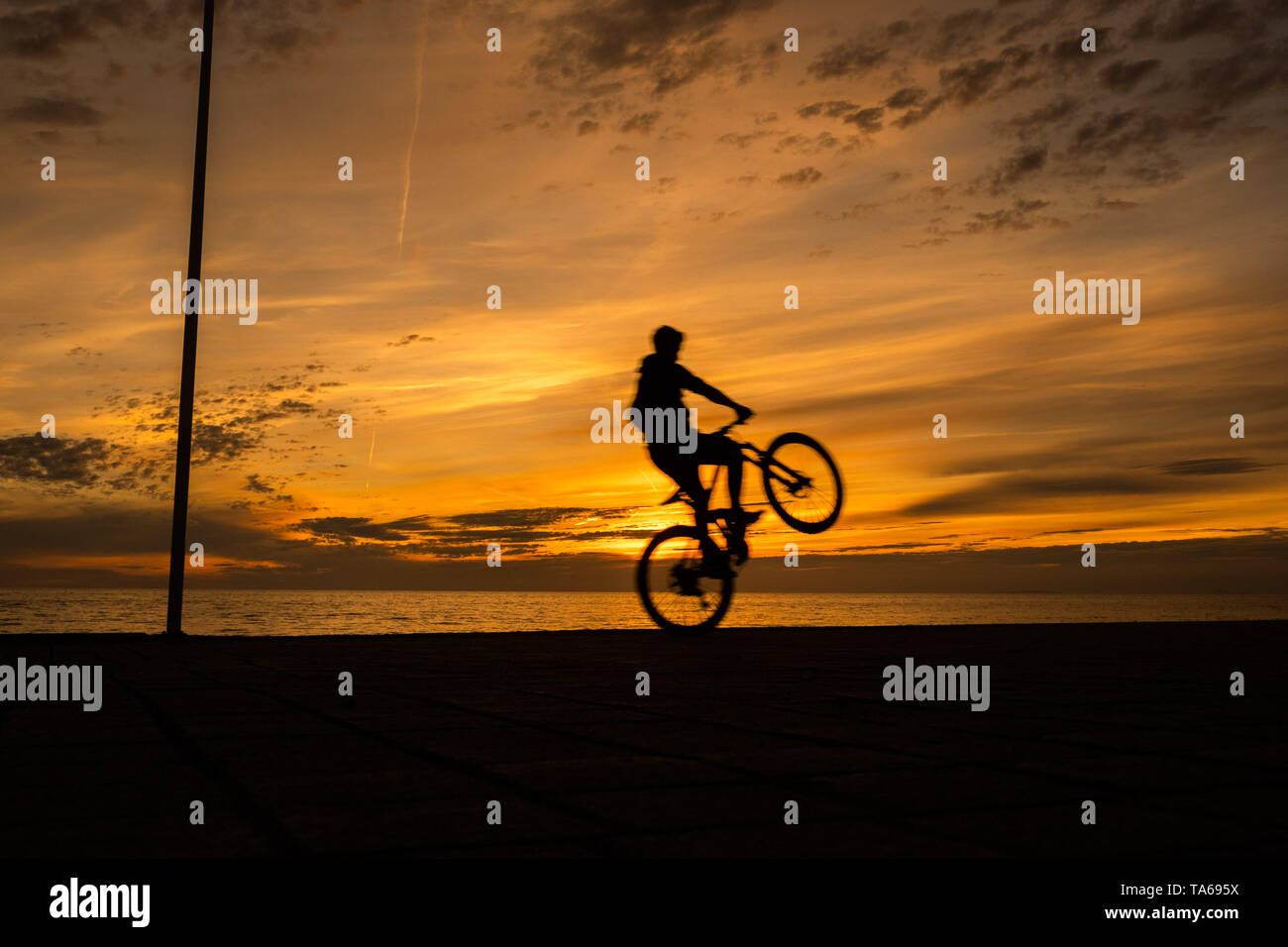 Pays de Galles Aberystwyth UK, le mercredi 22 mai 2019 UK Weather : Les gens se profilant à vélo le long de la promenade au coucher du soleil à Aberystwyth sur une soirée légère peut, à la fin d'une journée de printemps chaud soleil sur la côte ouest du pays de Galles. Crédit photo : Keith Morris / Alamy Live News Banque D'Images