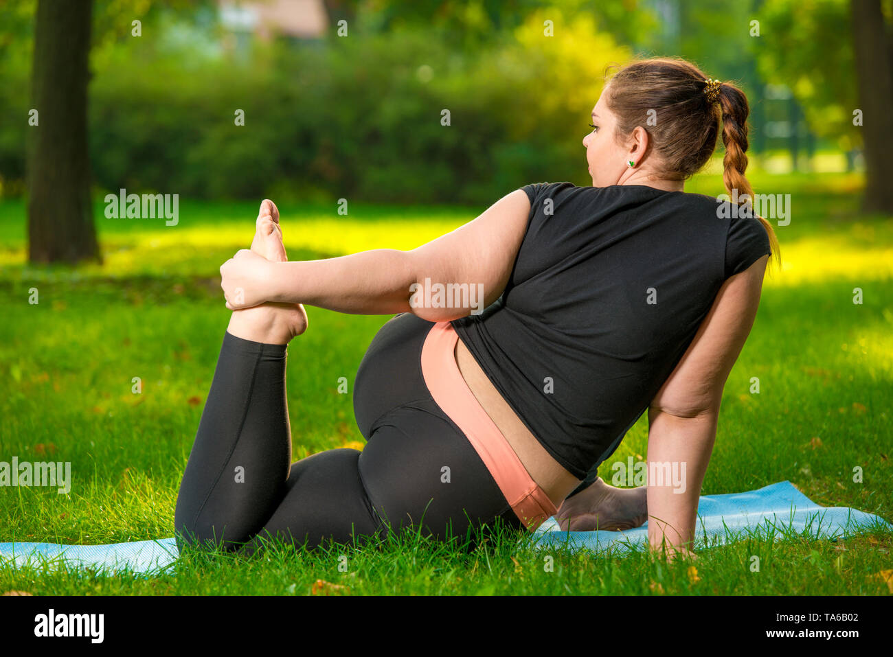 Grosse femme dans le parc faisant du yoga grande taille femme est tres souple et solide Photo Stock Alamy