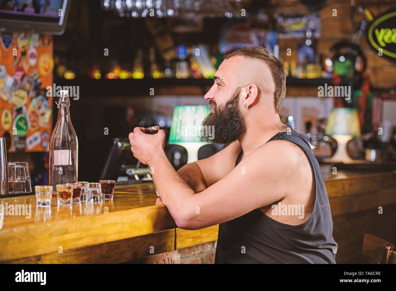 L'homme brutal Hipster de boire de l'alcool de commande plus d'un verre au  comptoir du bar. Guy dépenser en loisirs bar avec de l'alcool. L'homme ivre  assis seul dans un pub. L'alcoolisme