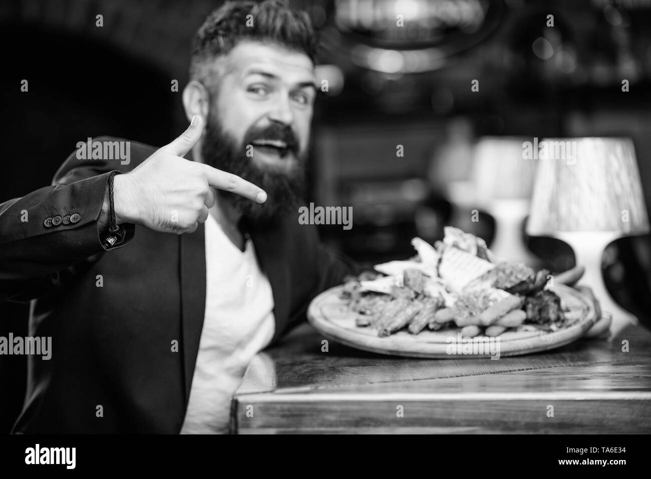 Costume officiel Gestionnaire de siéger au comptoir du bar. L'homme a reçu de pommes de terre frites repas avec les bâtonnets de poisson viande. Délicieux repas. Profitez de repas. Des calories. Tricher repas. Hipster faim manger pub aliments frits. Banque D'Images