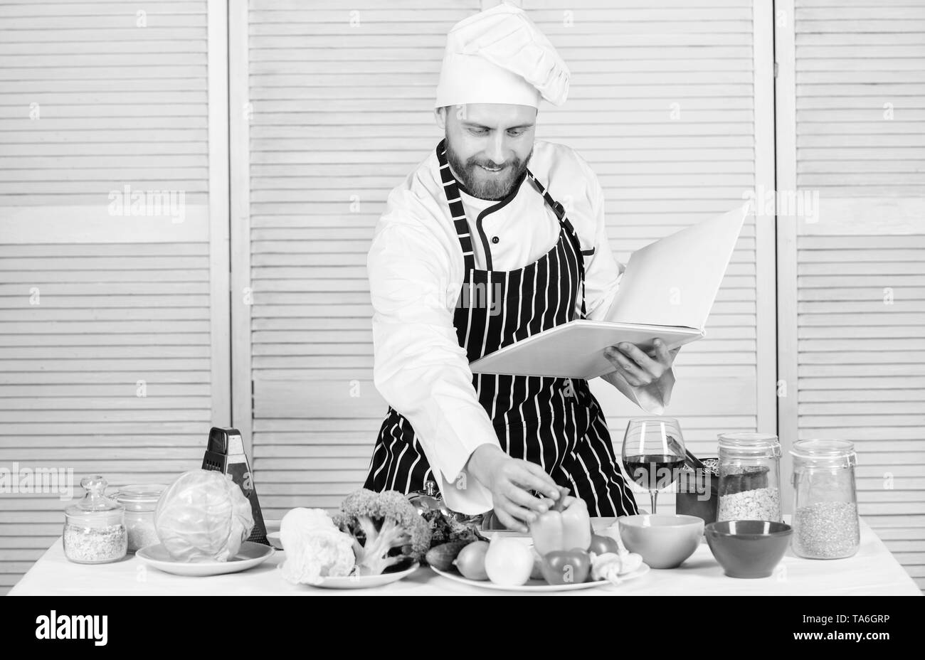 Livre des recettes de famille. Guide de cuisson ultime pour les débutants. Selon recette. Chef barbu homme à la cuisson des aliments. Guy lire livre de recettes. Concept d'arts culinaires. Apprendre l'homme recette. Améliorer les compétences de cuisson. Banque D'Images