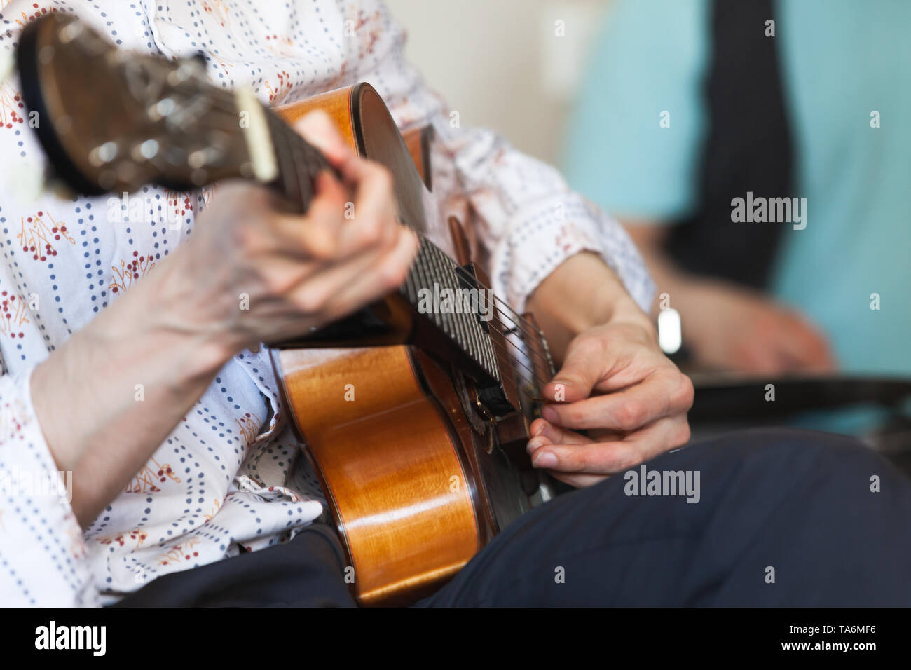 Homme jouant une guitare acoustique avec médiateur, close-up photo avec selective focus Banque D'Images