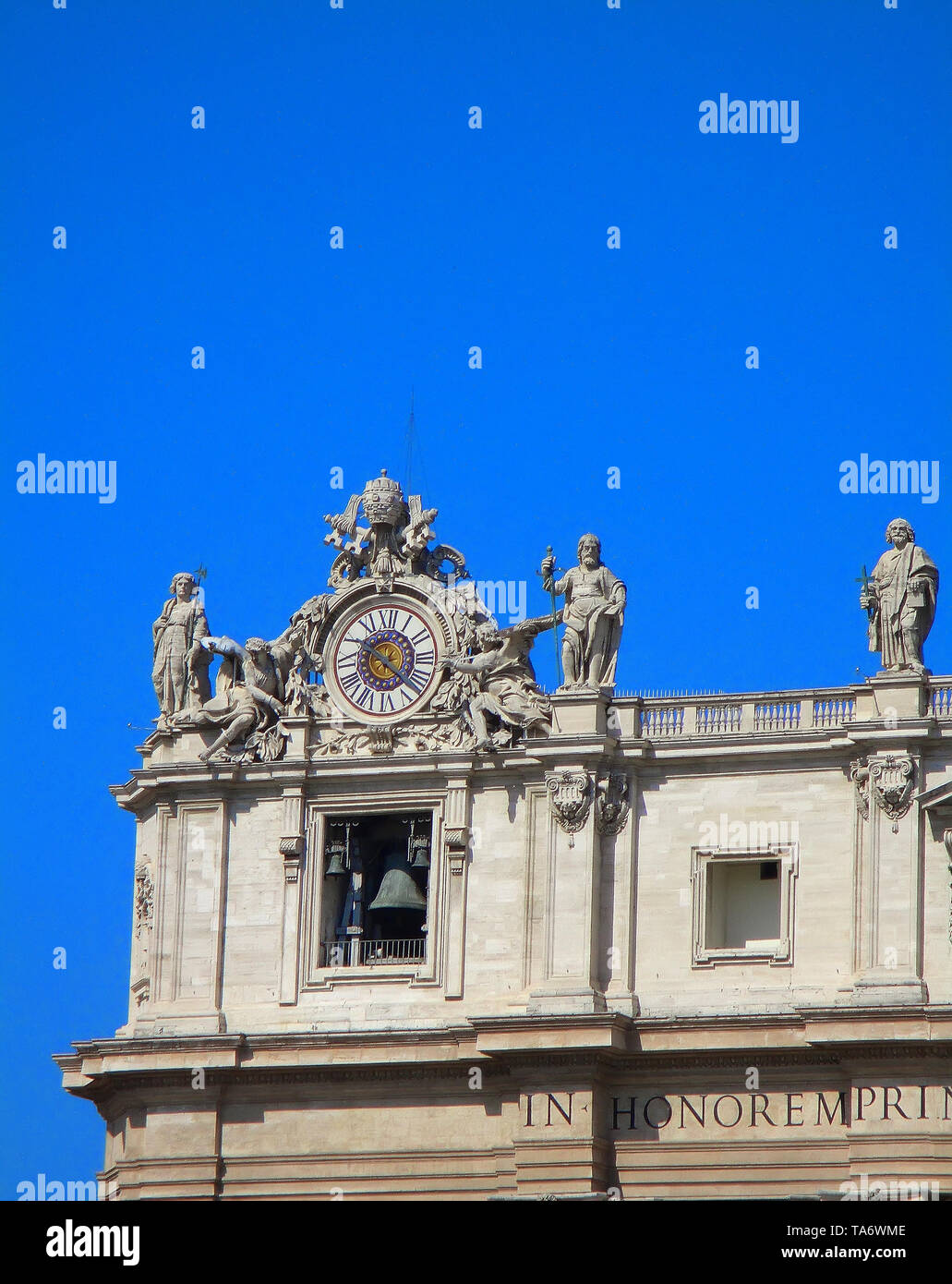 Les éléments architecturaux de célèbres monuments - Basilique Saint Pierre de style baroque façade : sculptures, Bell et de l'horloge sur un fond de ciel bleu. Banque D'Images