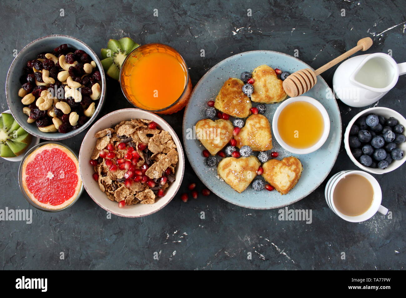 Petit-déjeuner ou brunch concept sur fond sombre. Vue de dessus avec l'exemplaire de l'espace. Petit déjeuner sain. Petit-déjeuner sain crêpes, fruits secs, café, barres granola. Banque D'Images