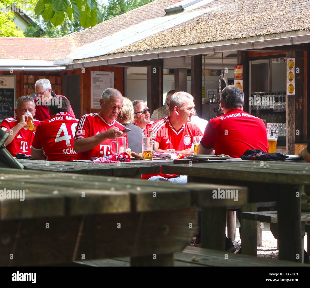 GARCHING, ALLEMAGNE - Fans du FC Bayern portant le t-shirt du club de football de boire une bière dans un jardin de bière avant le match Banque D'Images