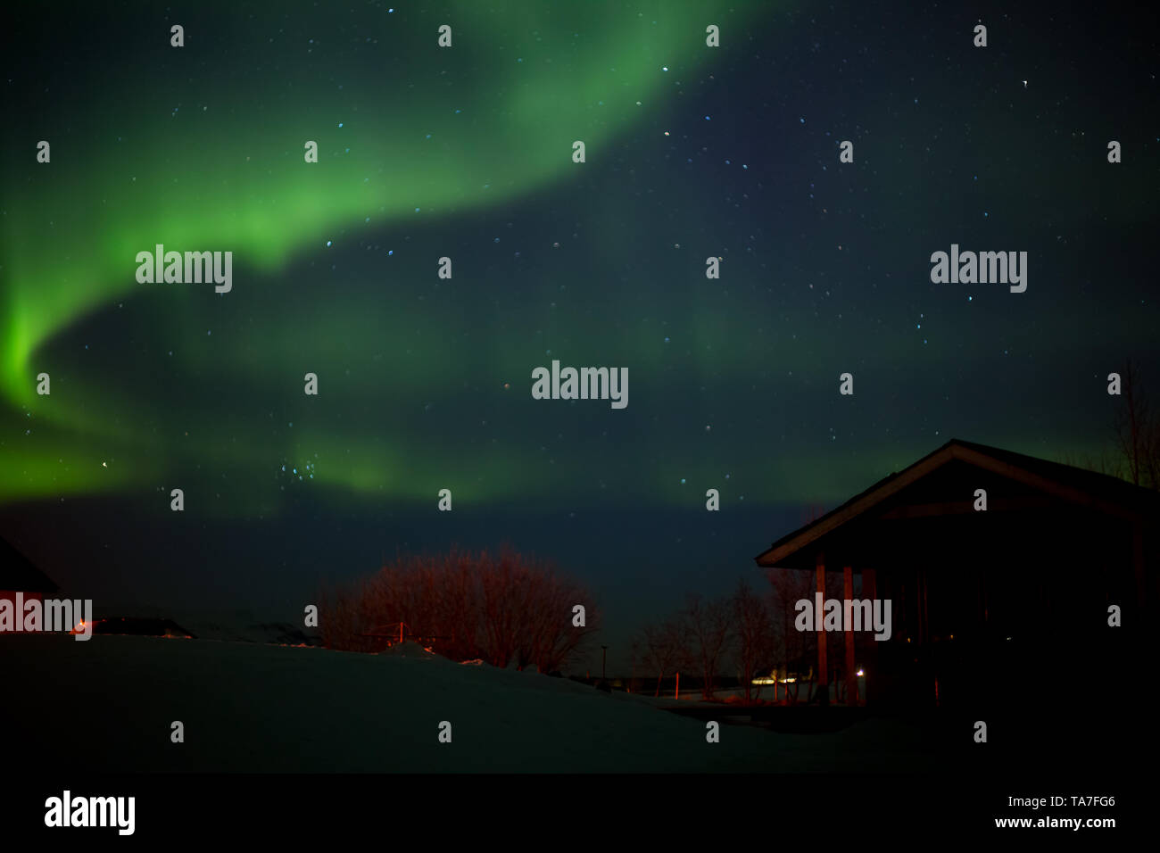 Dancing lumières polaires avec bungalow en premier plan en hiver en Islande Banque D'Images