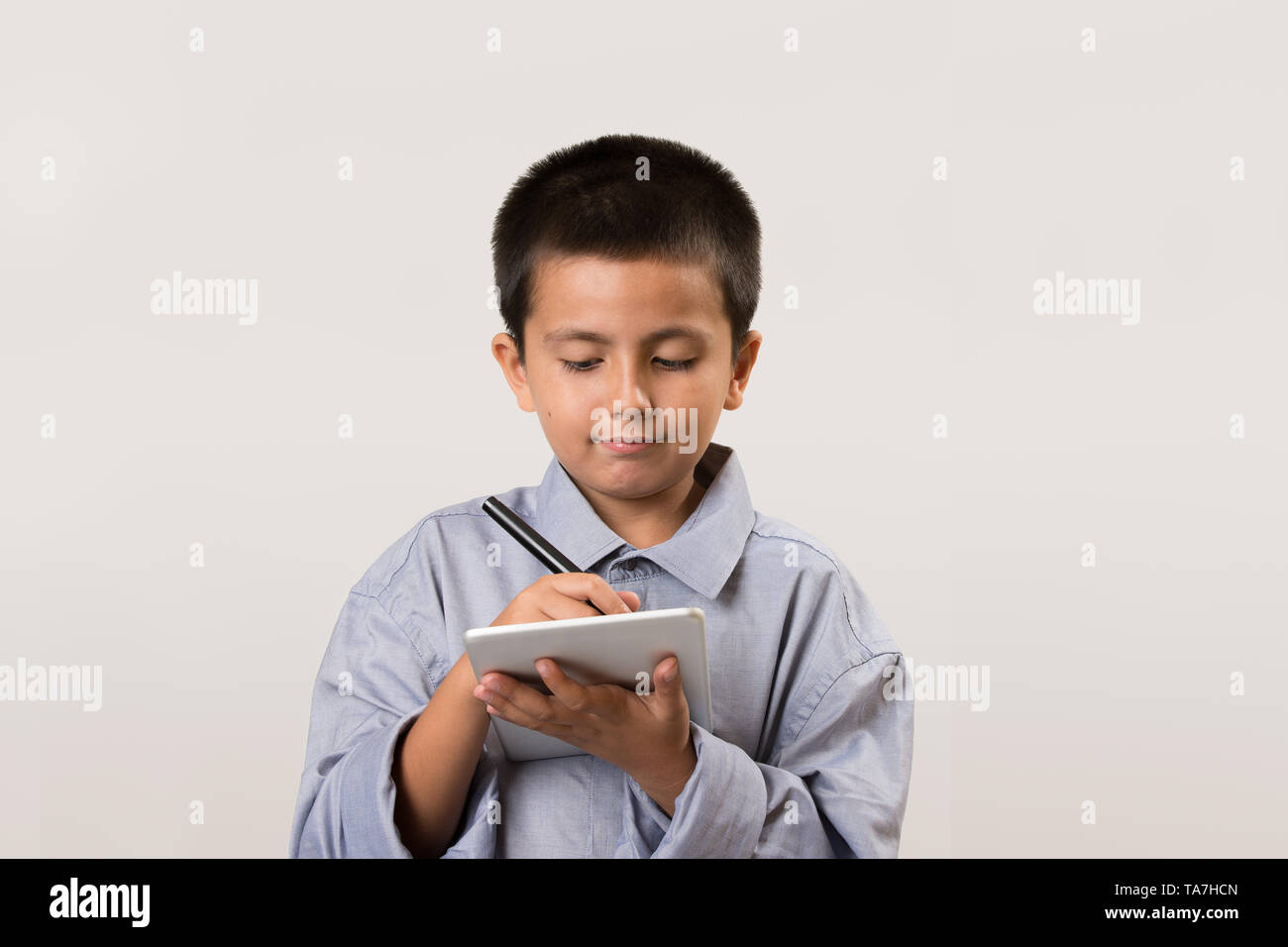 Jeune garçon portant ses pères shirt faisant semblant d'être homme d'affaires avec les appareils numériques et un stylo. L'éducation de la petite enfance, l'apprentissage jouer avec copie de l'image concept Banque D'Images