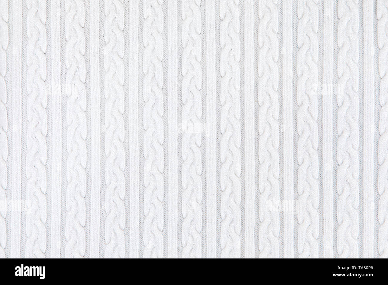 Texture Tissu tricot avec des nattes et de rayures. Tricot Machine répéter la texture de chandail. Tricot blanc Arrière-plan. Banque D'Images