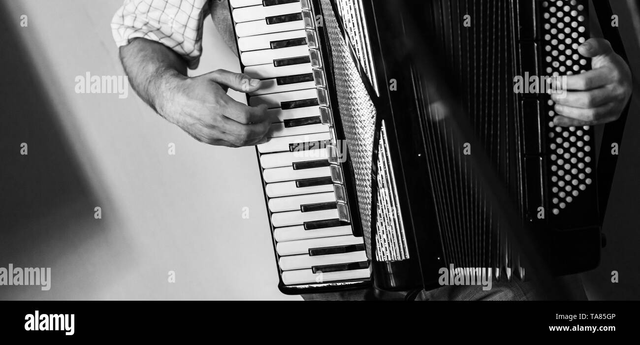 L'accordéoniste joue vintage accordéon. Close-up photo en noir et blanc avec soft focus sélectif Banque D'Images