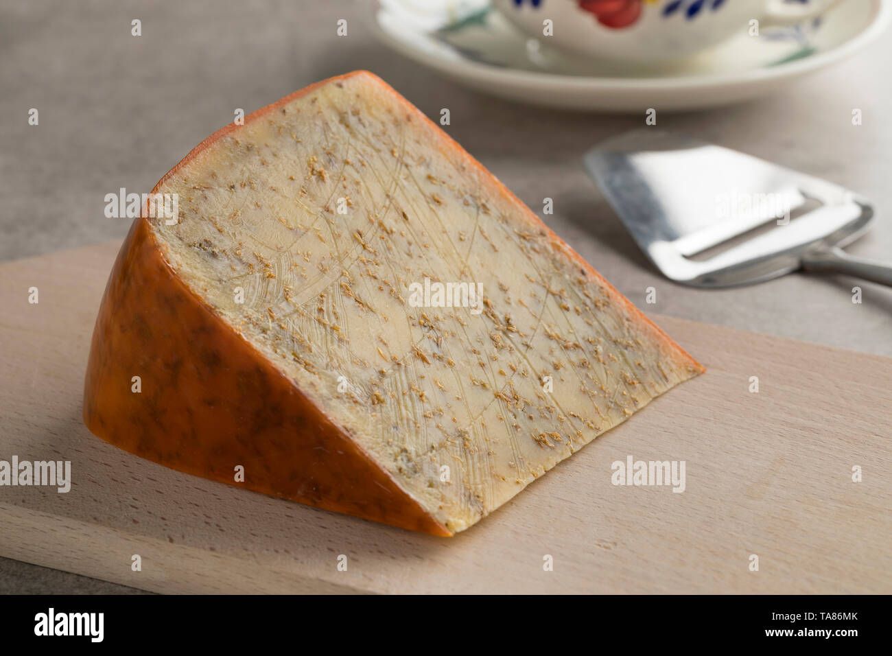 Vieux morceau de fromage au cumin matures à partir de la partie nord de Hollandon une planche à découper Banque D'Images