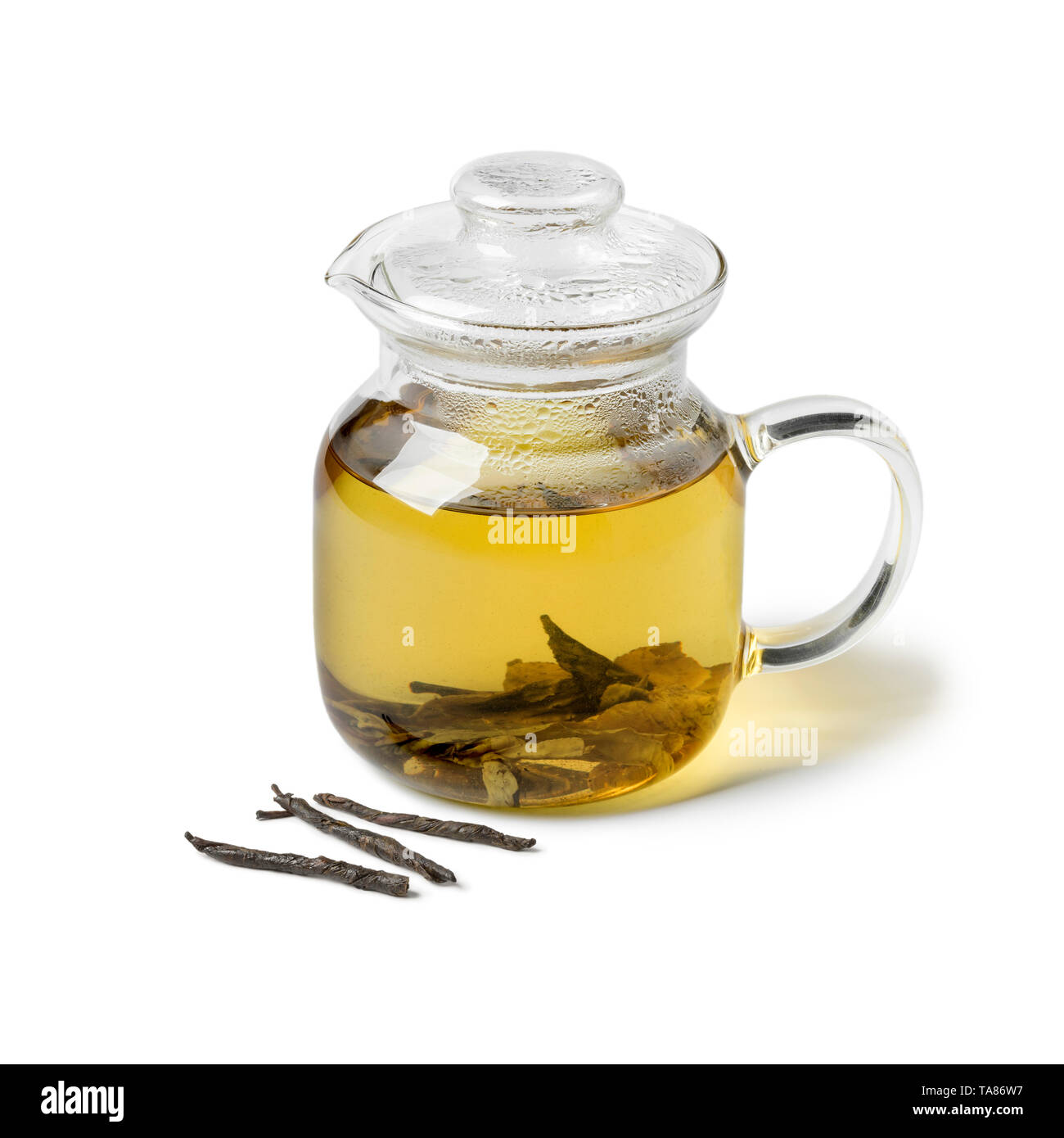 Théière en verre avec Kuding thé chinois aiguille isolé sur fond blanc Banque D'Images