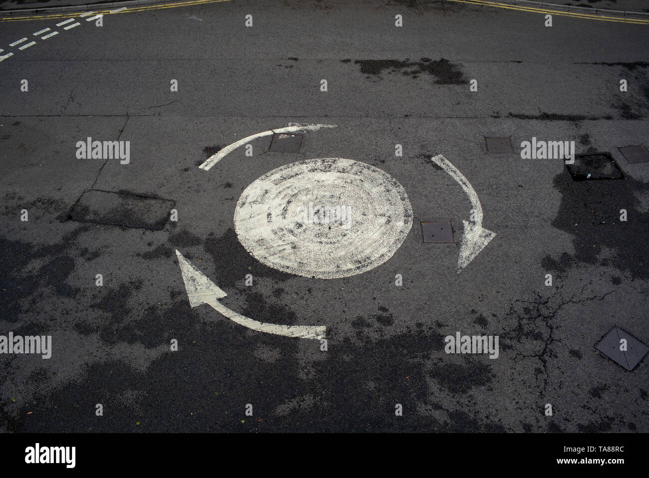 Une vue aérienne d'une route peint flèche rond-point avec pas de voitures sur pourrait être utilisé pour analogie ou la notion de droit d'être confus ou perdus etc. Banque D'Images