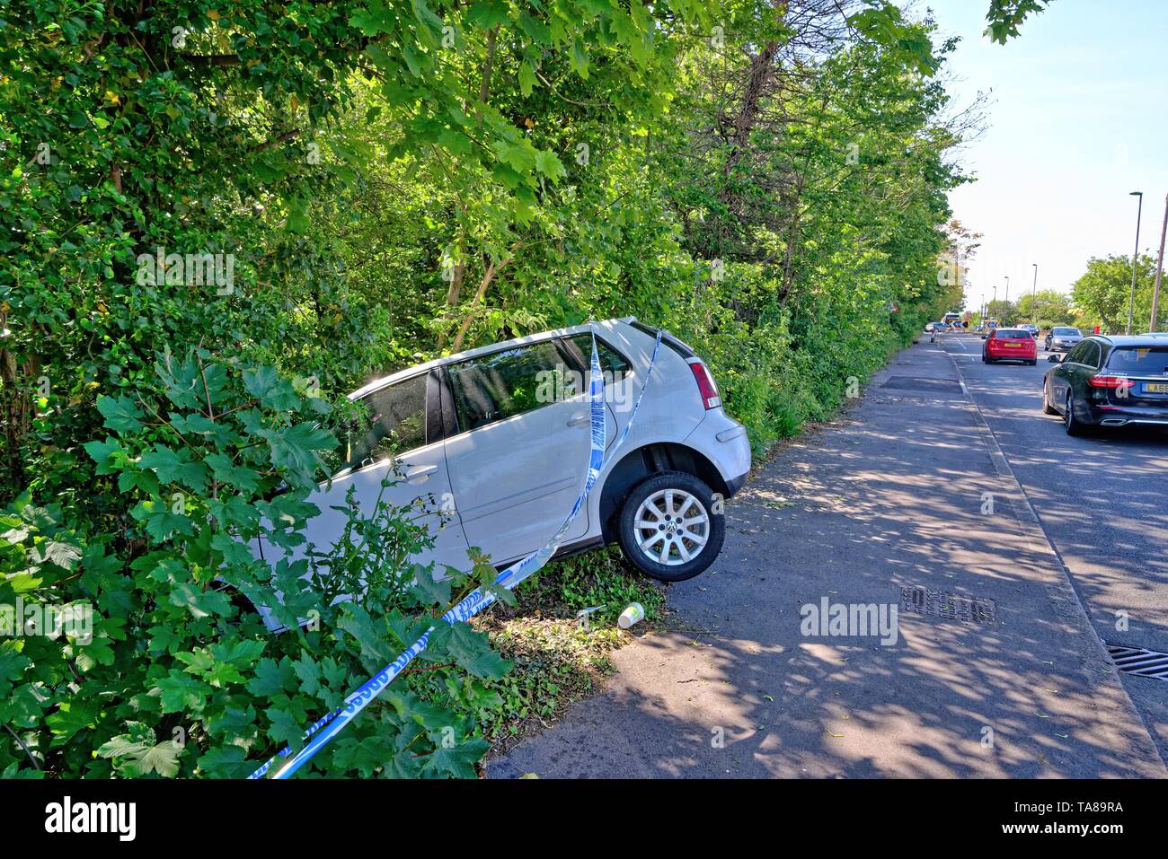 Une berline blanche face vers le bas dans un fossé après avoir perdu sur une route principale, Shepperton Surrey England UK Banque D'Images