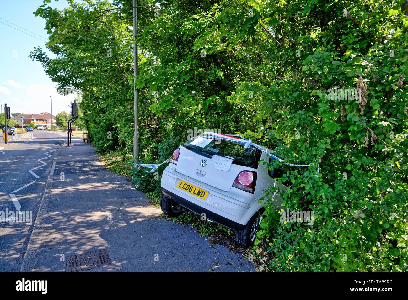Une berline blanche face vers le bas dans un fossé après avoir perdu sur une route principale, Shepperton Surrey England UK Banque D'Images
