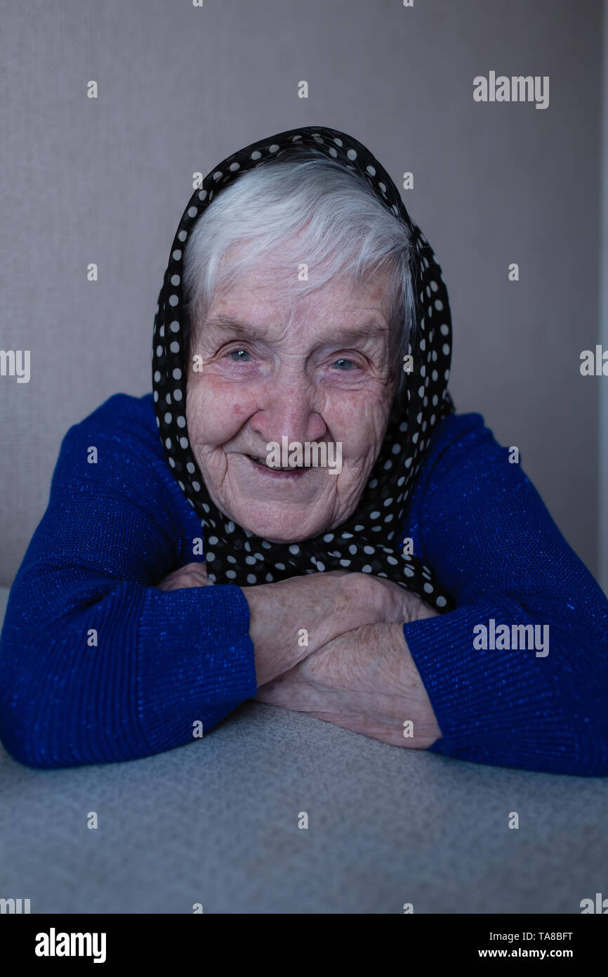 Portrait d'une vieille femme pension dans un foulard sur sa tête. Banque D'Images