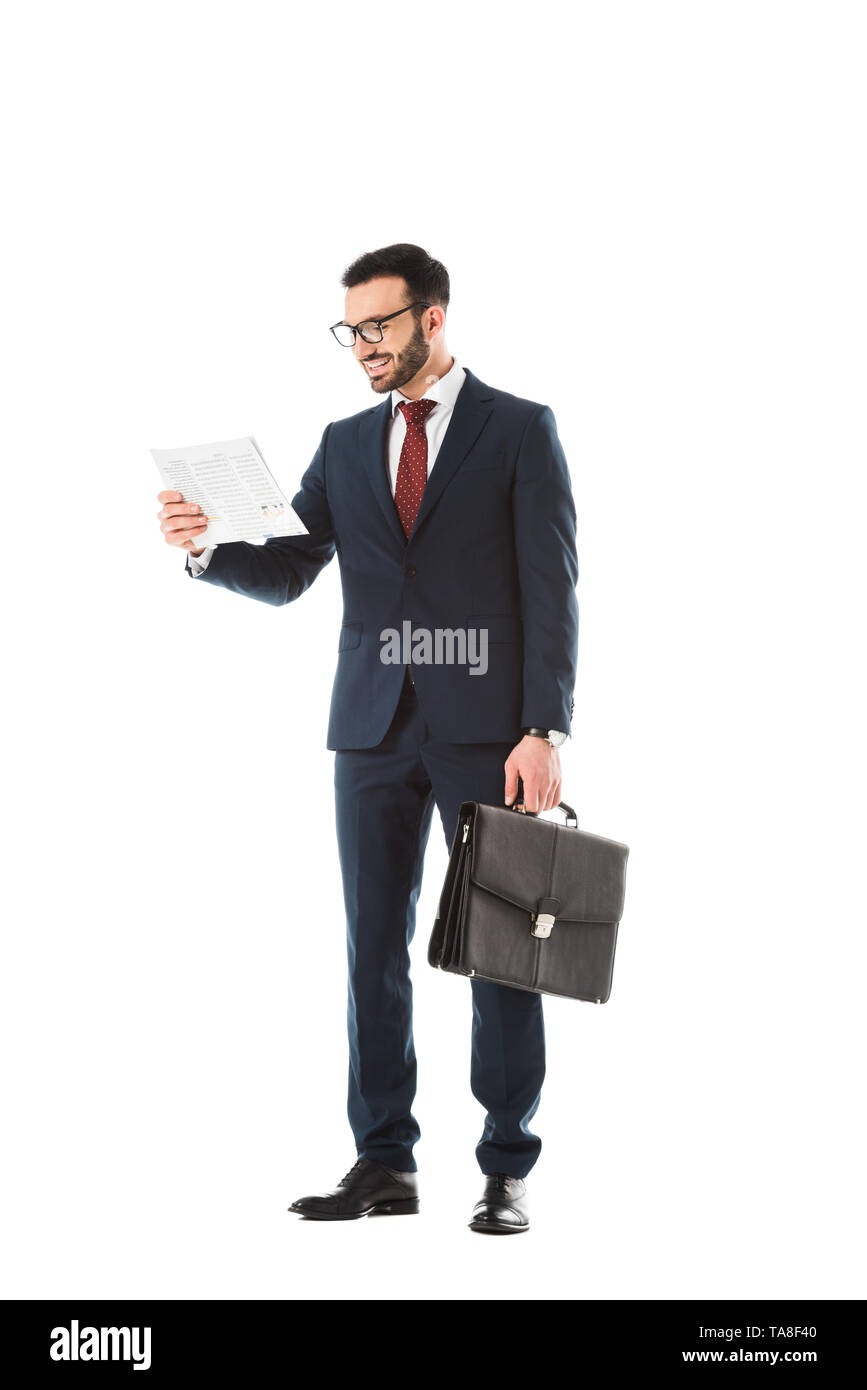 Cheerful businessman with briefcase reading newspaper isolated on white Banque D'Images