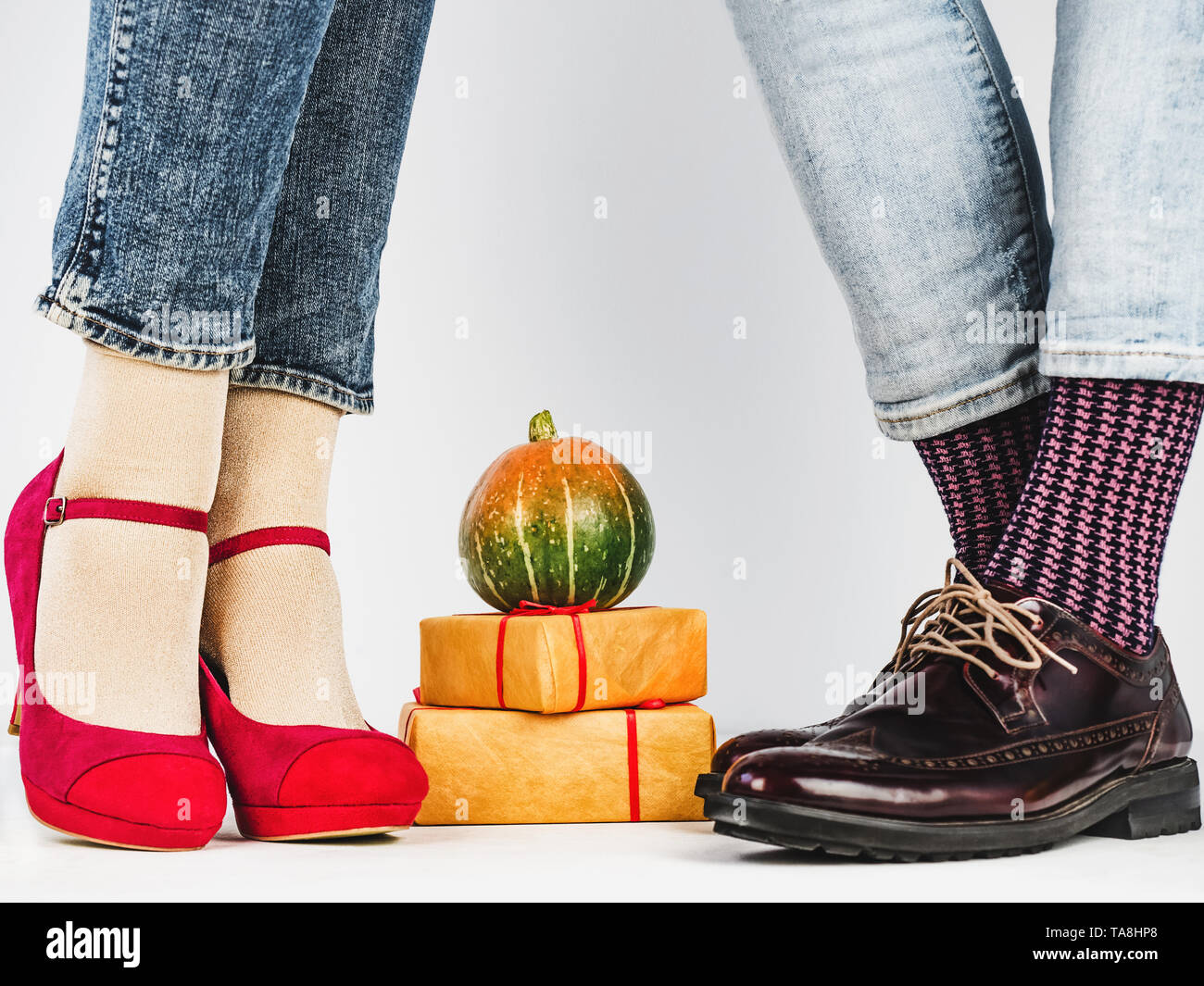 Les hommes et les femmes chaussures à la mode dans les jambes, coloré, chaussettes multicolores sur un fond blanc, isolé. Close-up. Concept de style, la mode et être Banque D'Images