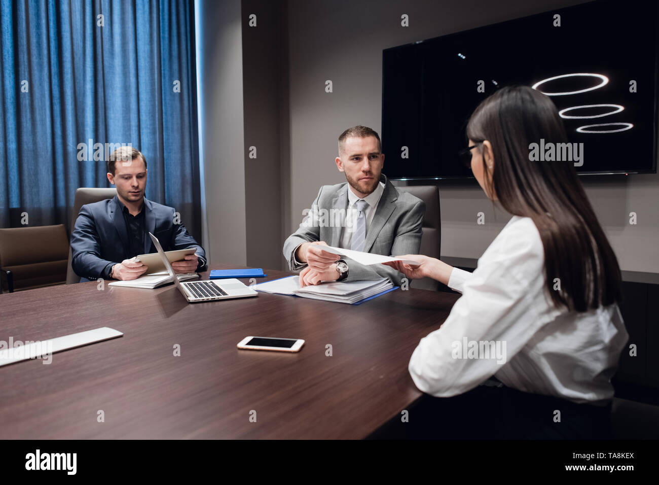 Jeune entreprise, l'entreprise créative des gens de différentes races et de l'âge se rassembler dans une salle de réunion dans l'intérieur de bureau moderne sombre, vivously à discuter Banque D'Images