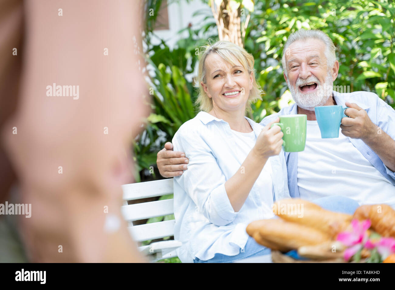 Des moments heureux. L'âge de la retraite joyeuse gentil couple prenant le thé et de rire tout en profitant de leur temps ensemble - Image Banque D'Images