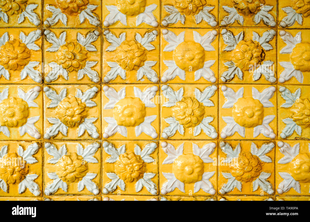 Vieux et sale de secours jaune vif, avec motif floral. Les carreaux de céramique émaillée Vintage la texture et l'arrière-plan. Banque D'Images