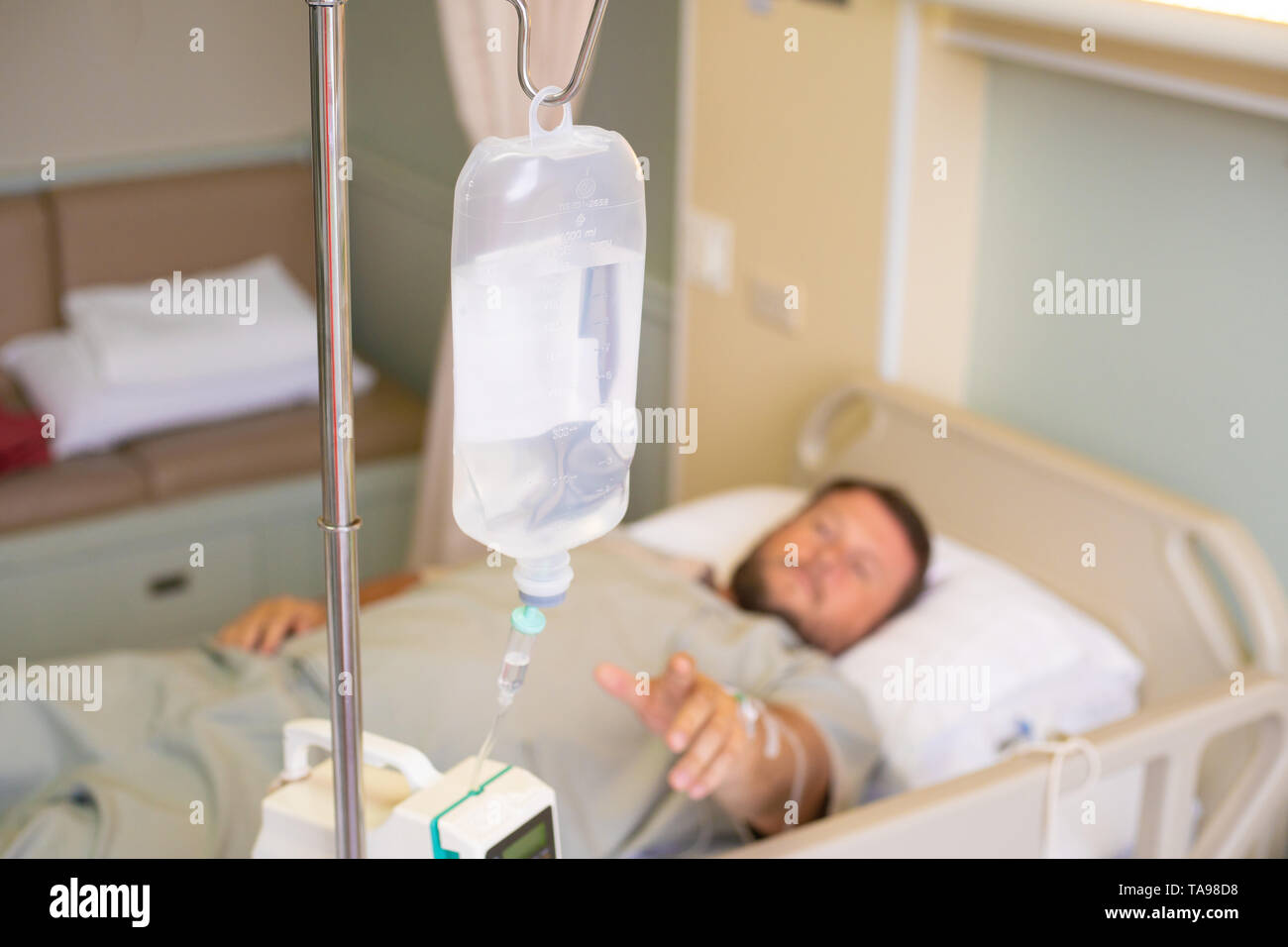 Close-up. Côté masculin avec un compte-gouttes pendant la chimiothérapie dans un hôpital. L'homme est dans la chambre d'hôpital, sans accent. La santé est un sujet de la santé et Banque D'Images