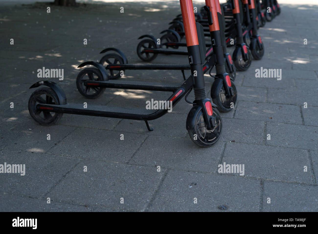 Ville moderne et écologique à louer des scooters électriques à l'extérieur, sur le trottoir. Le tourisme alternatif, le transport autour de la ville, le service de remplacement de vélo. E- Banque D'Images