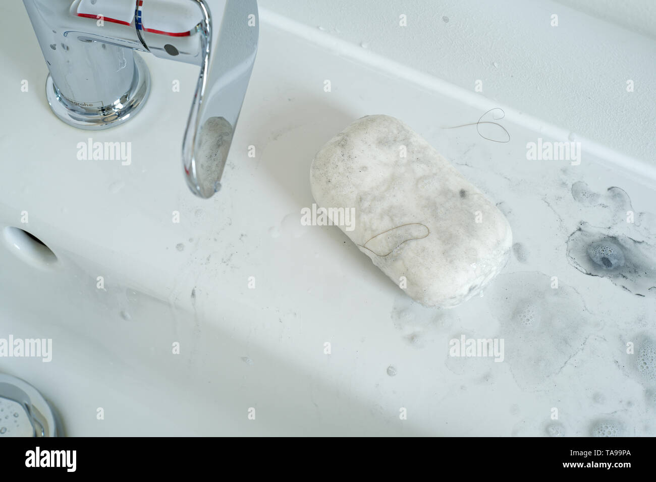 Savon sale sert à nettoyer de la saleté et la graisse par le côté d'un évier. Banque D'Images