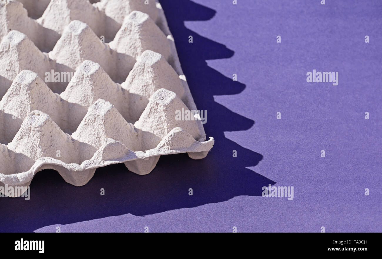 Libre d'une boîte de papier pour carton d'oeufs oeufs sur mauve avec des ombres. Concept de l'utilisation d'emballages biodégradables et la réduction de l'utilisation de plastique, copy space Banque D'Images