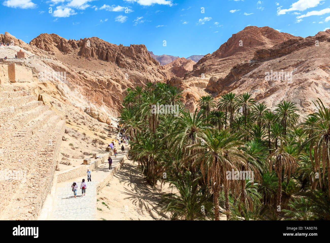 TOZEUR, TUNISIE-vers mai, 2012 : les visiteurs à pied à Chebika (Qasr el-Shams) oasis de montagne au pied du Djebel el Negueb dans l'ouest de la Tunisie. Il est fam Banque D'Images