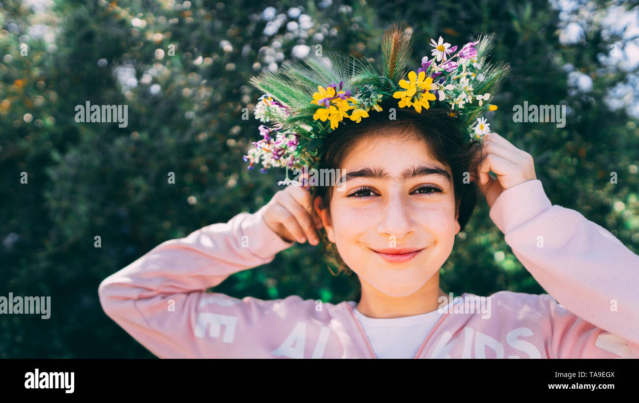 Portrait d'une belle petite fille portant des couronnes de fleurs. Peu caucasian girl avec couronne de fleurs. Banque D'Images