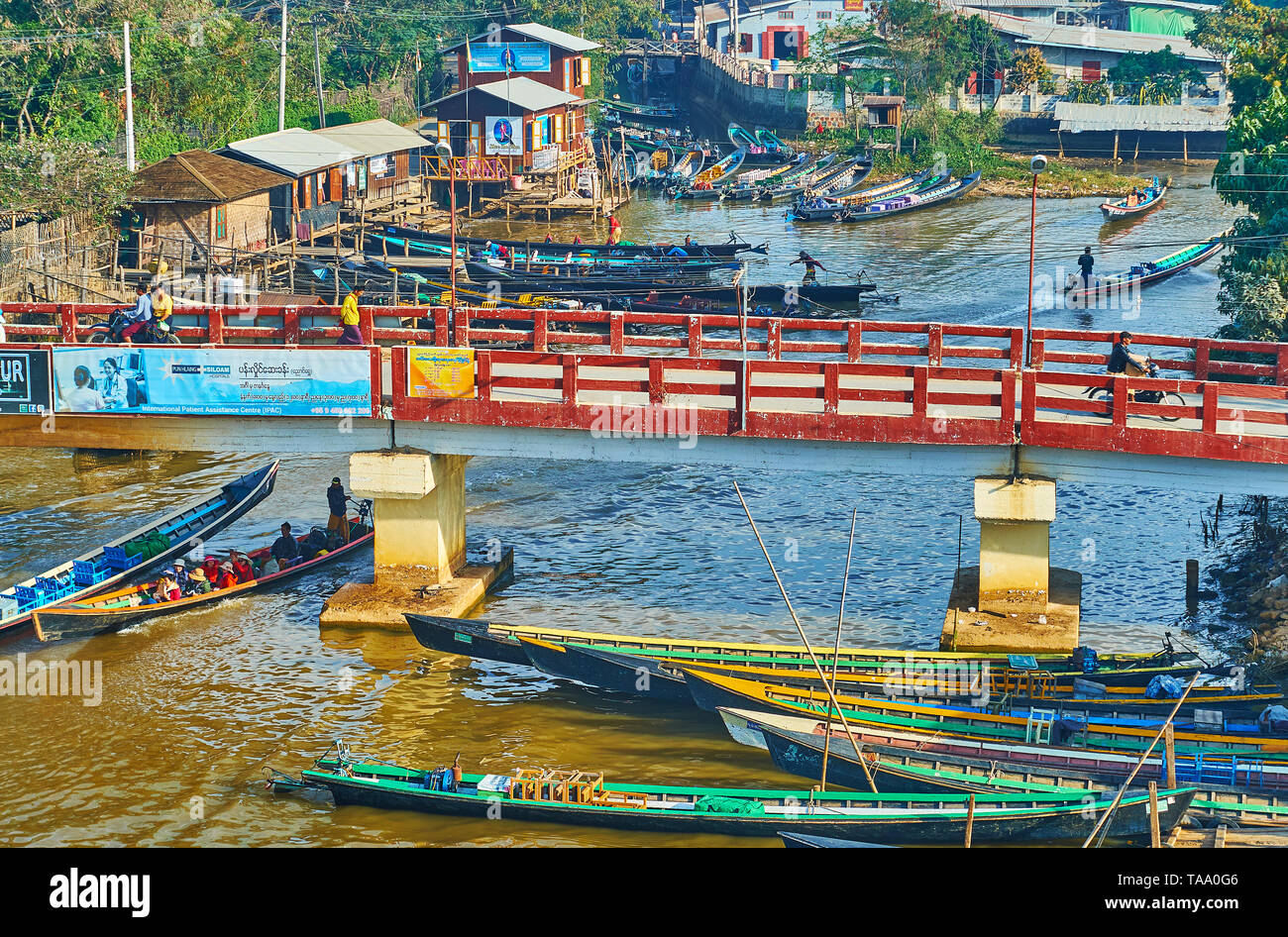 NYAUNGSHWE, MYANMAR - février 19, 2018 : Le rapide kayaks passer sous le pont bas sur le canal du lac Inle, le 19 février à Nyaungshwe. Banque D'Images