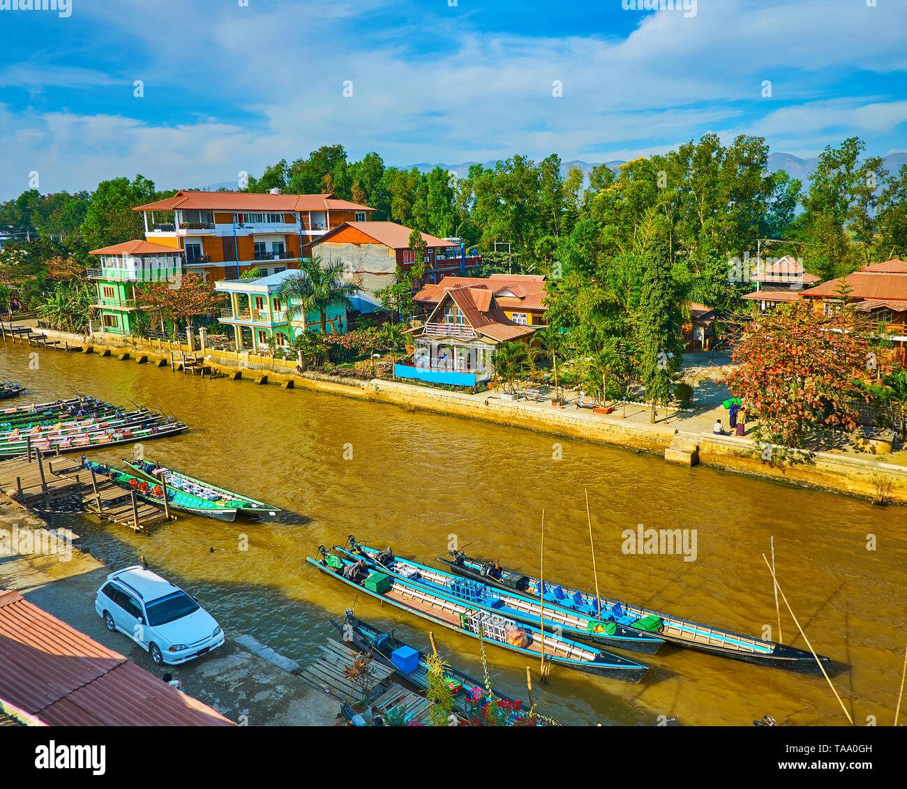 Le paysage du village touristique avec vue sur canal, pleine de kayaks, barques amarrées le long des berges ou flottant au lac Inle, Nyaungshwe, Myanmar. Banque D'Images