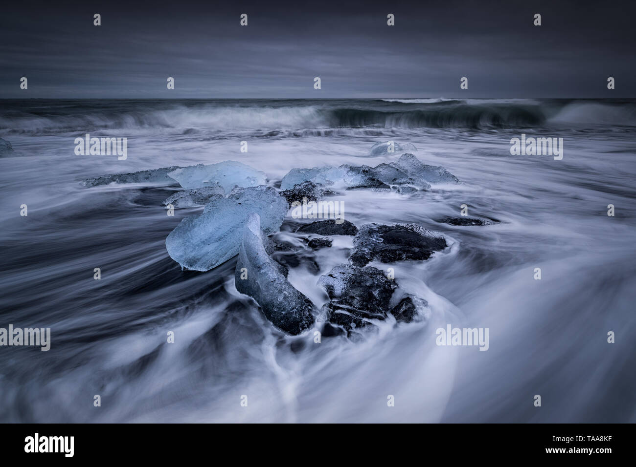 Dérives dans la mer autour de l'icebergs et de la glace des glaciers qui est balayée sur la plage sur le sable noir à Jokulsarlon, Islande Banque D'Images