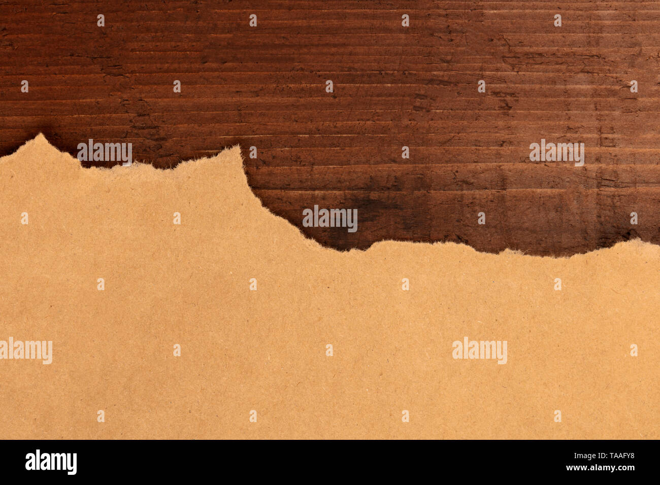 Un morceau de papier kraft brun déchirés, tourné par le haut sur un fond rustique foncé, un grunge design avec une place pour le texte Banque D'Images