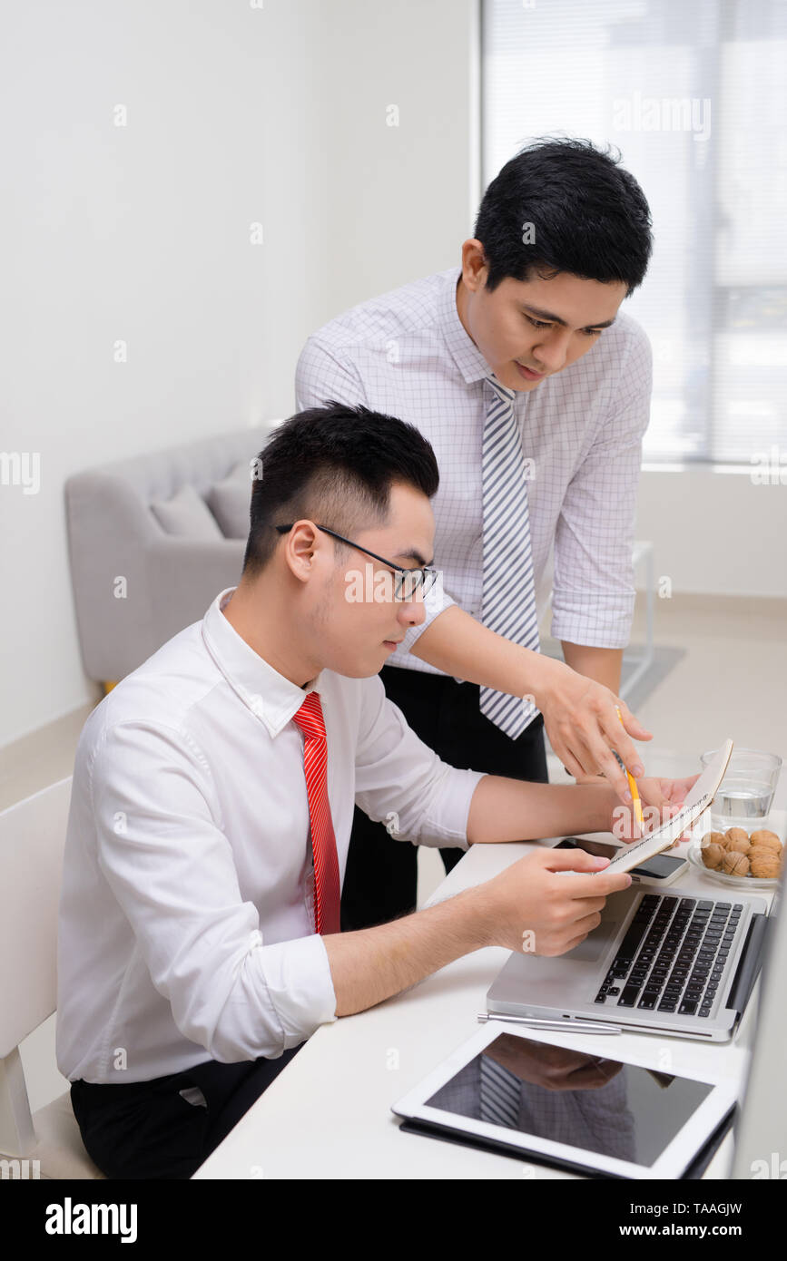Image de deux jeunes hommes d'interaction at meeting in office Banque D'Images