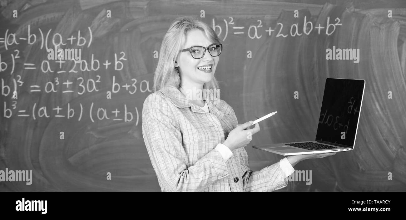 Les technologies numériques concept. Smart éducateur dame avec ordinateur portable moderne tableau internet surf arrière-plan. Enseignante portent des lunettes est titulaire d'ordinateur portable Internet surf. L'éducation scolaire de base. Banque D'Images