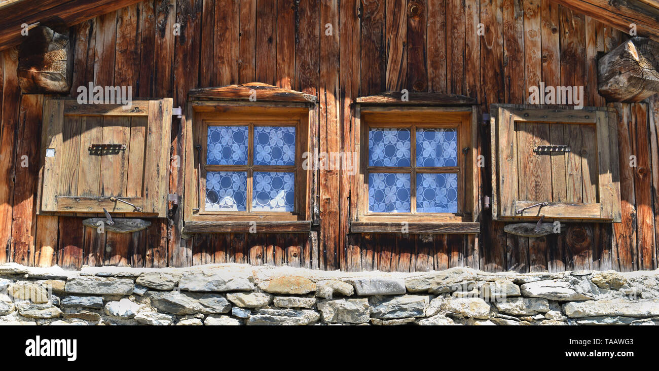 Près de deux petite fenêtre sur une façade d'un chalet de montagne Banque D'Images