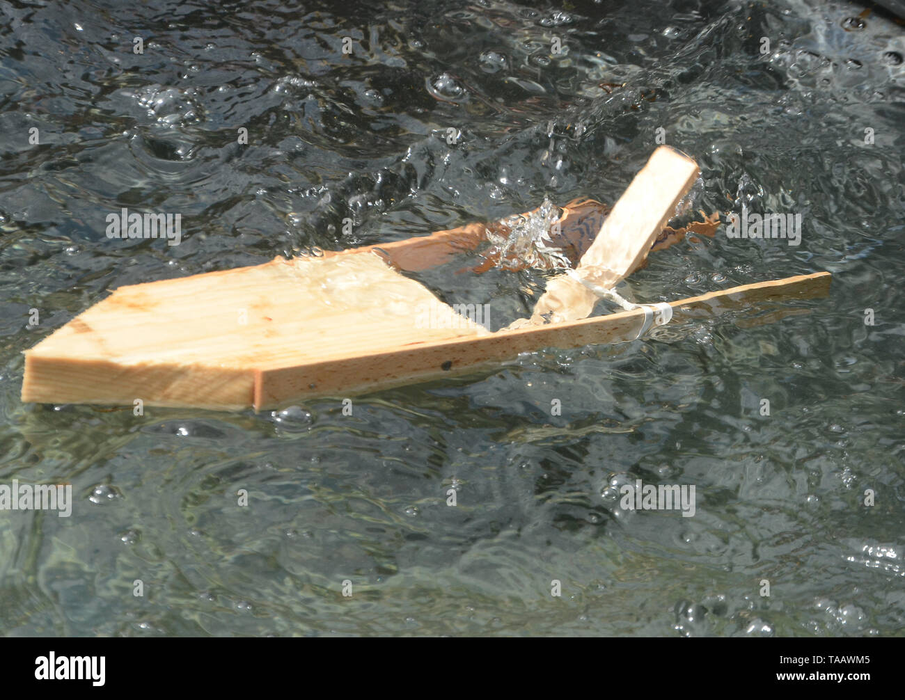 Modèle simple bateau avec moteur élastique propulse son chemin sur une surface de l'eau. Banque D'Images