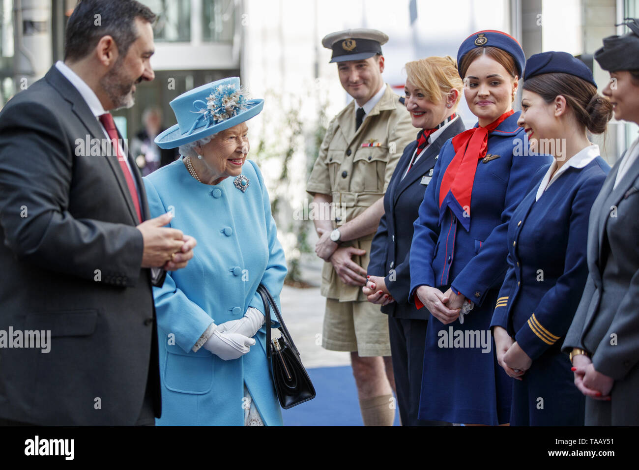 La reine Elizabeth II s'accompagne d'Président de British Airways, Alex Cruz (à gauche) alors qu'elle répond aux employés vêtus de l'uniforme du patrimoine lors de sa visite au quartier général de la British Airways à l'aéroport de Heathrow, Londres, à l'occasion de leur centenaire. Banque D'Images