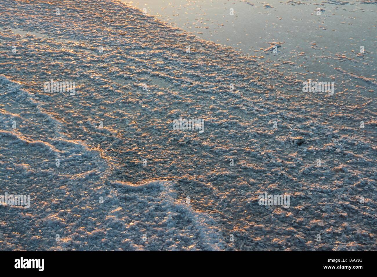 Larnaca, Chypre - séchage du sel sur la rive du lac salé au coucher du soleil la lumière. Banque D'Images