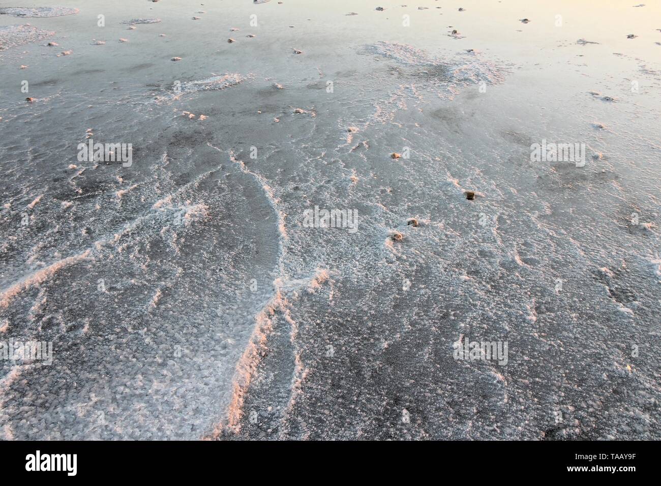 Larnaca, Chypre - séchage du sel sur la rive du lac salé au coucher du soleil la lumière. Banque D'Images