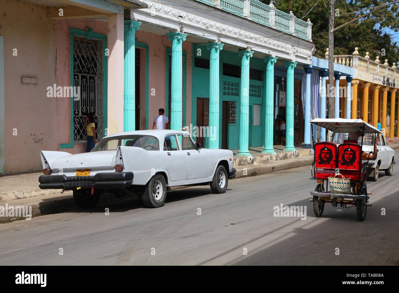 MORON, CUBA - février 19, 2011 : les gens à pied passé vieille voiture à Moron, Cuba. Cuba a l'un des taux de location par habitant élevés (38 pour 1000 personnes en 2008) Banque D'Images