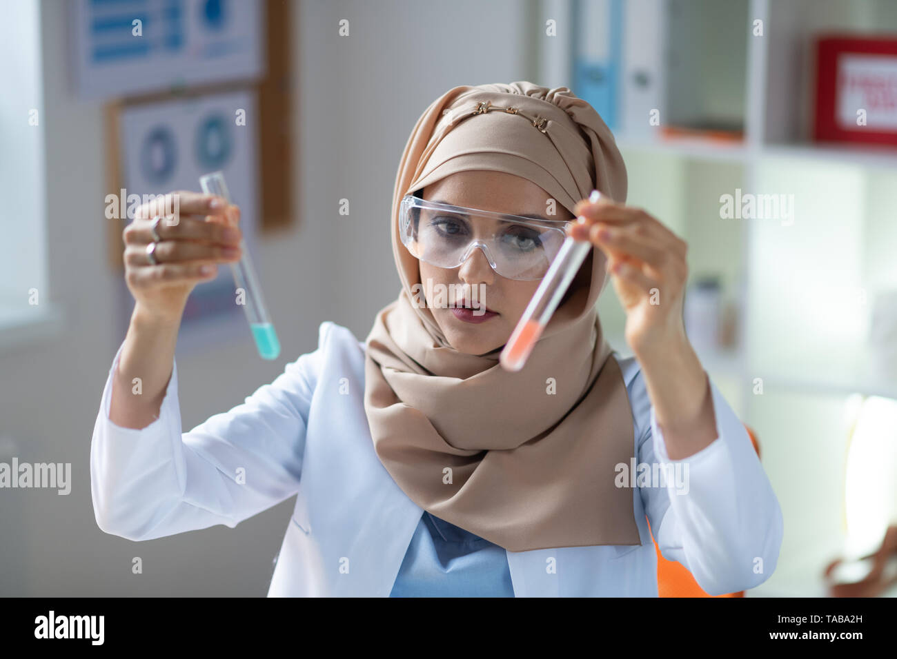 Deux tubes à essai. Le chimiste femelle portant des lunettes tenant deux tubes à essai avec des liquides Banque D'Images