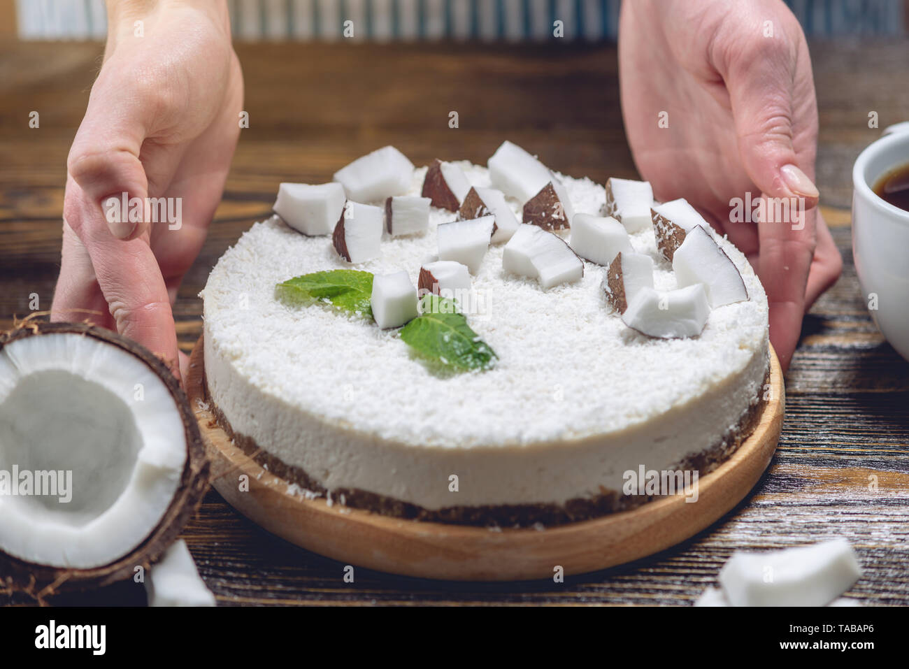 La noix de coco gâteau pâtissier décore brut avec de la pâte blanche et la menthe sur fond de bois. L'été frais et sain dessert vegan. L'alimentation sans gluten et sans sucre Banque D'Images