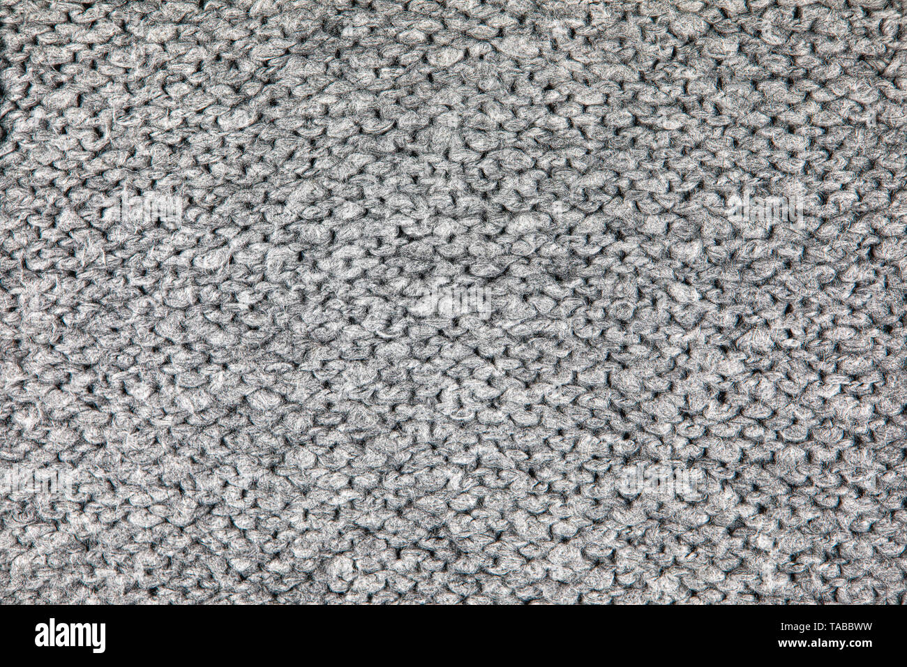 Tissu maille lâche avec la texture de laine. Tricot Machine à répétition de Texture chandail chaud. Fond tricoté gris. Banque D'Images