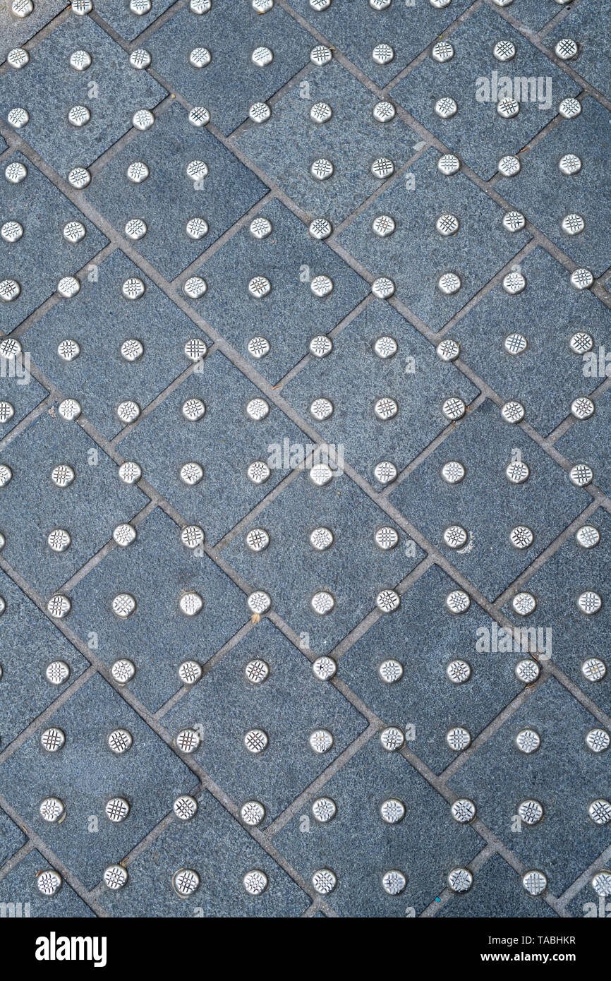 Carreaux de sol en pierre cloutés résumé sur une zone piétonne Road à Londres, Angleterre Banque D'Images