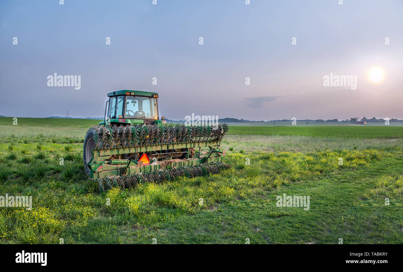 Tracteur agricole avec timon dans un champ sur une ferme du Maryland au coucher du soleil Banque D'Images